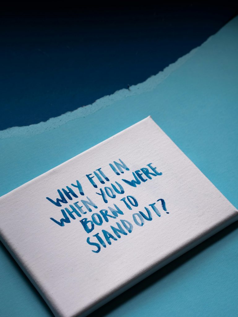 Canvas with motivational quote 'Why fit in when you were born to stand out?' on blue background.
